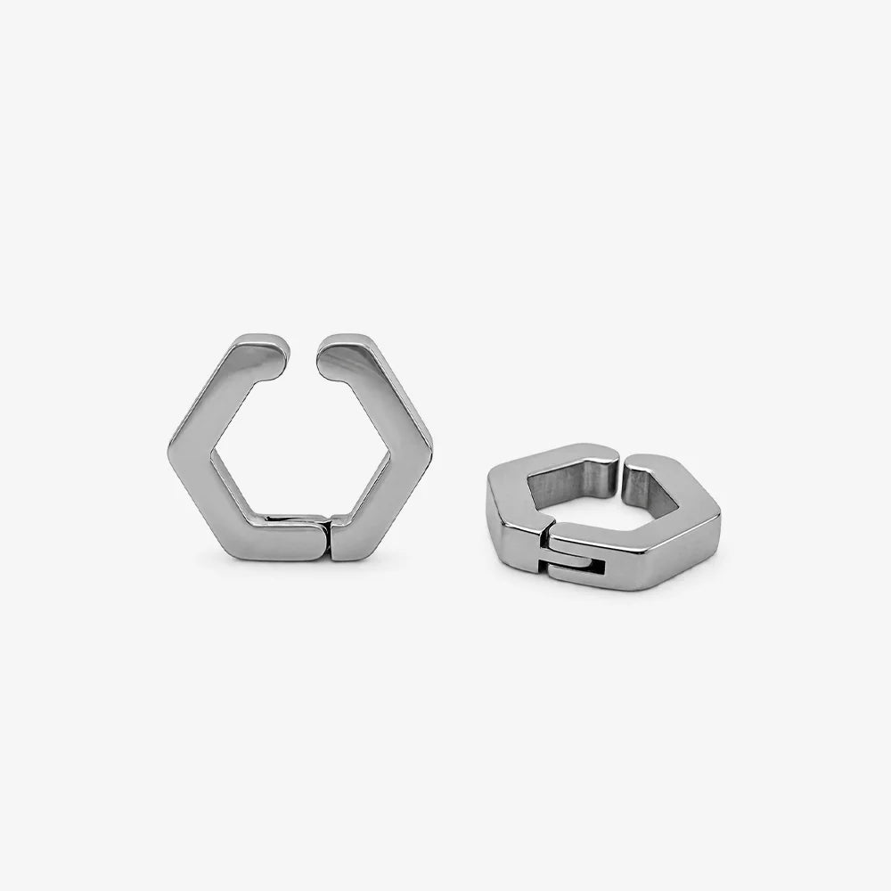 A pair of silver-toned geometric hoop earrings with a hexagonal open design, displayed on a clean light gray background.