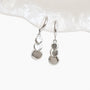 Close up detail of the graduated grey discs on silver clip on drop earrings