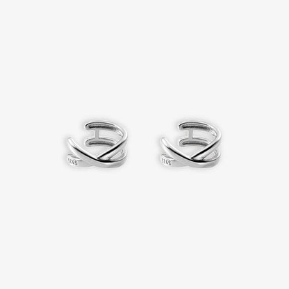 A pair of shiny silver Helix Cross Ear Cuffs against a white backdrop. These conch cuffs boast a spiral design that snugly fits the ear, making a statement perfect for special events or as a striking addition to formal wear.