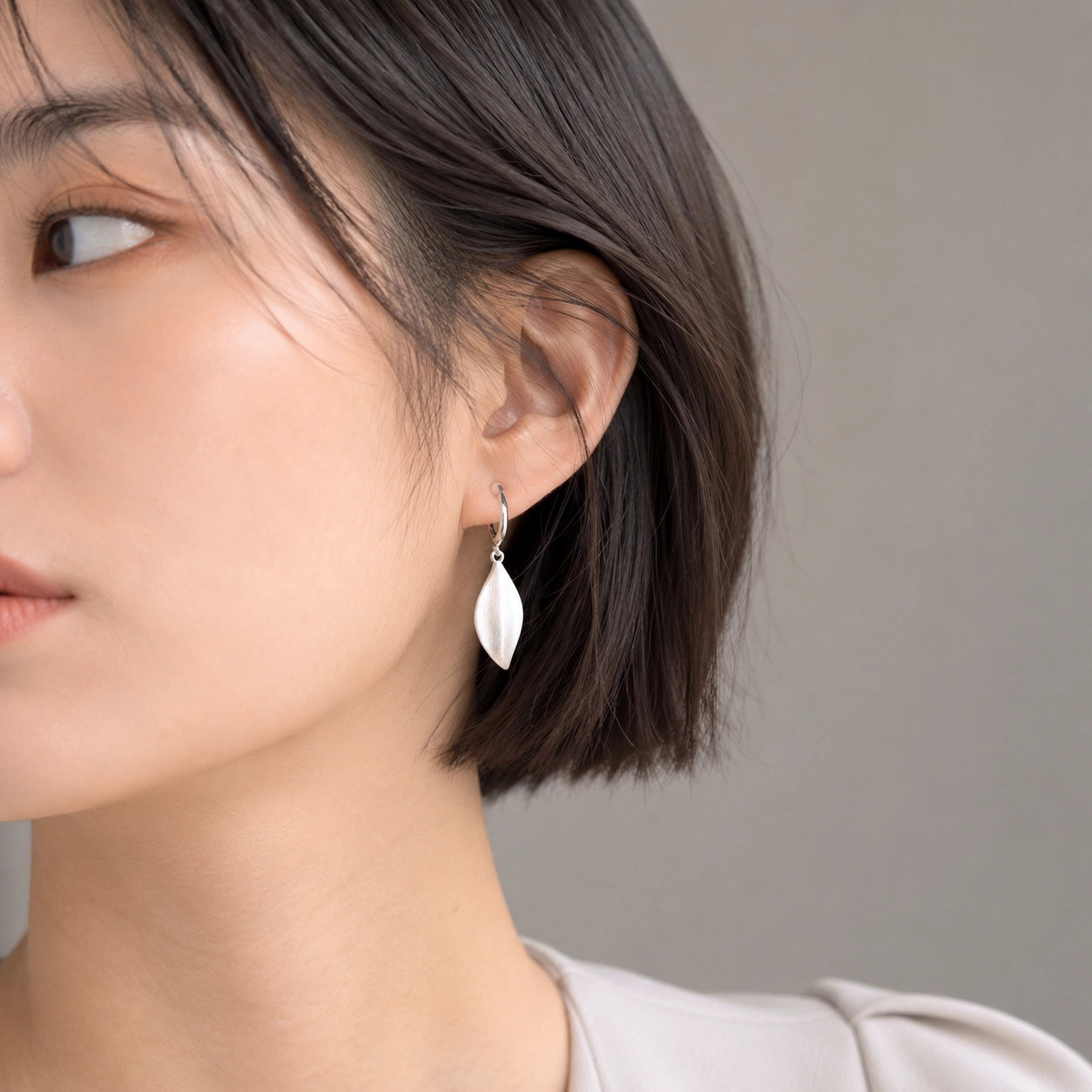 Woman wearing a silver leaf drop clip on earring on a non pierced ear