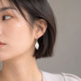 Woman wearing a silver leaf drop clip on earring on a non pierced ear