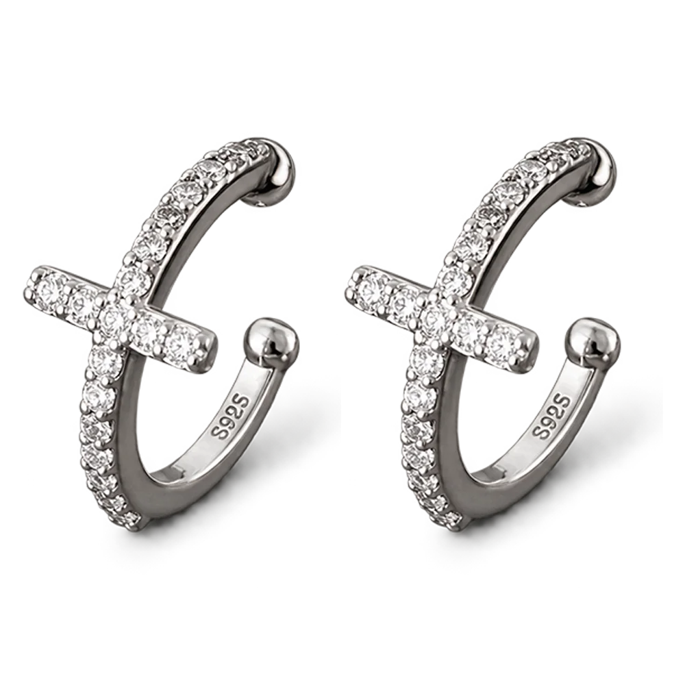 A pair of silver-toned huggie hoop earrings with a central cross design, both adorned with clear pavé stones. 