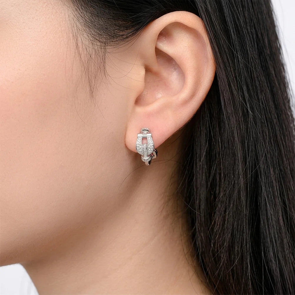 A model wearing the Silver Pave Horseshoe Clip On Earrings, demonstrating how the screw-back design mimics a real piercing on the earlobe.