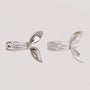 Vue arrière des boucles d'oreilles manchette en ruban argenté mettant en évidence le mécanisme à clip large et confortable, adapté à différents placements dans l'oreille.