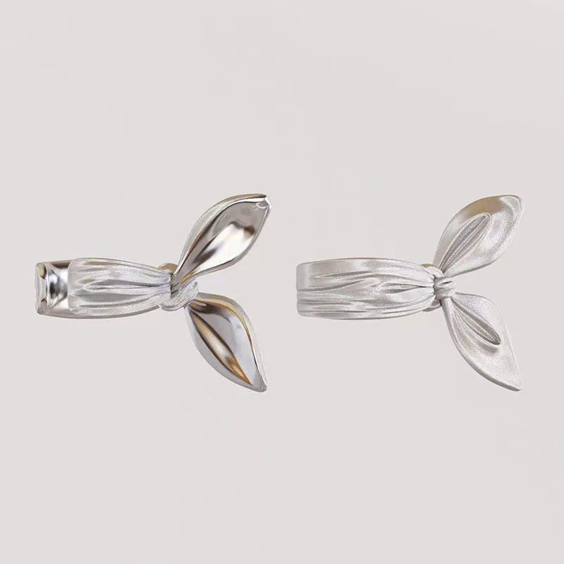 Vue arrière des boucles d'oreilles manchette en ruban argenté mettant en évidence le mécanisme à clip large et confortable, adapté à différents placements dans l'oreille.