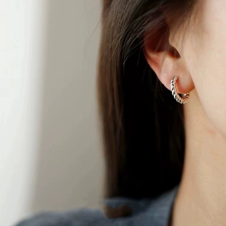 Woman wearing a silver twisted rope clip on hoop earring on a non pierced ear