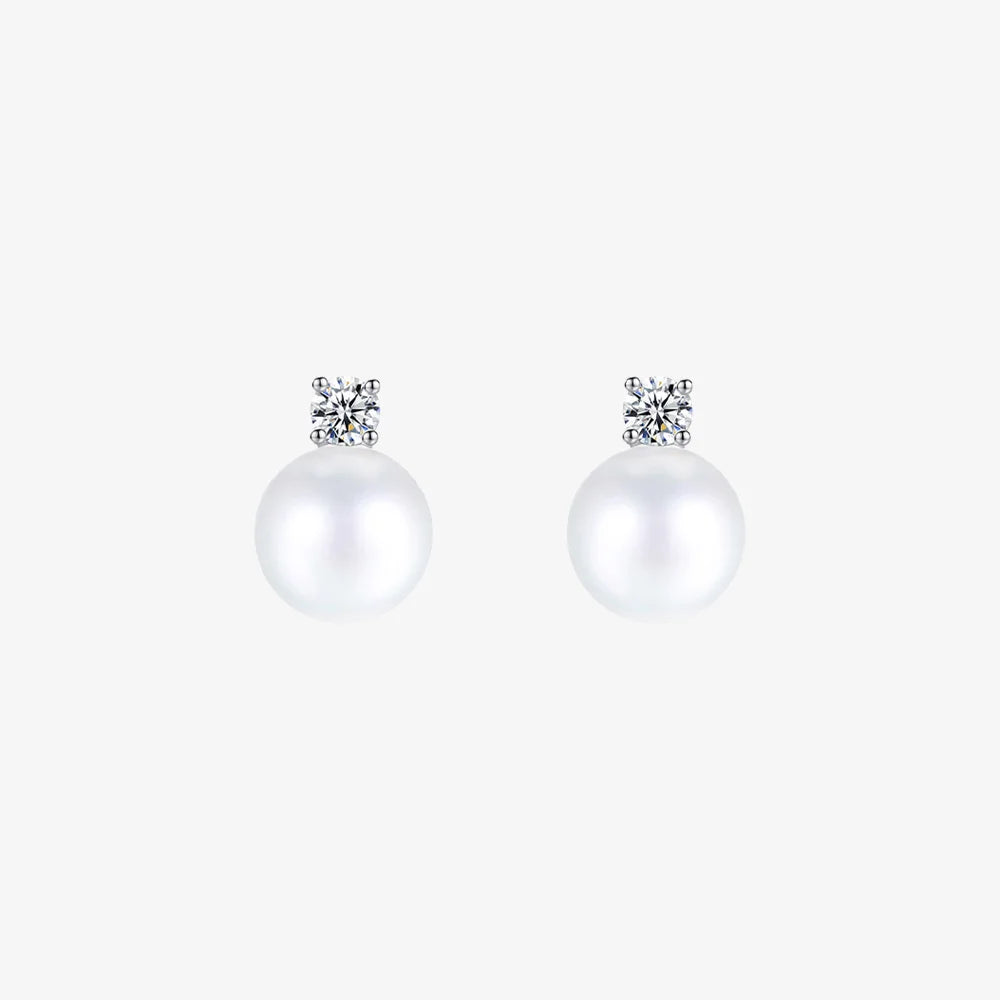 Pair of White Pearl Drop Clip-On Earrings in Silver Setting displayed on a soft beige surface, capturing the elegant design and color contrast.