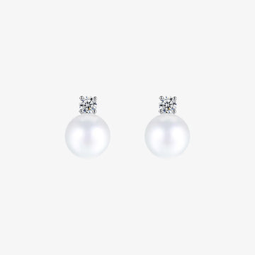 Pair of White Pearl Drop Clip-On Earrings in Silver Setting displayed on a soft beige surface, capturing the elegant design and color contrast.