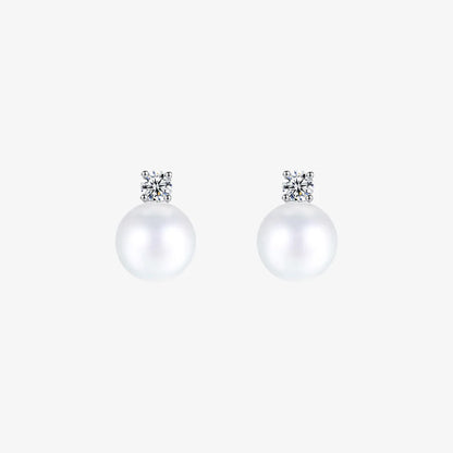 Pair of White Pearl Drop Clip-On Earrings in Silver Setting displayed on a soft beige surface, capturing the elegant design and color contrast.