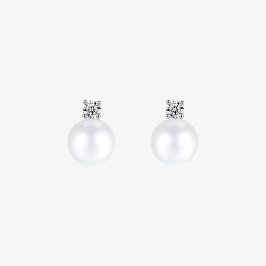 Pair of White Pearl Drop Clip-On Earrings in Silver Setting displayed on a soft beige surface, capturing the elegant design and color contrast.