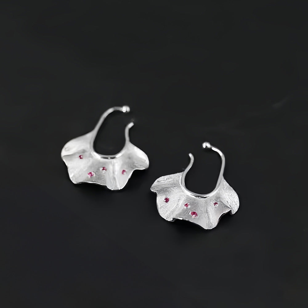 Elegant silver Ginkgo Leaf Conch Ear Cuff Earrings, each adorned with cherry red zircon, showcasing the intricate details and artful craftsmanship ideal for day to night wear.