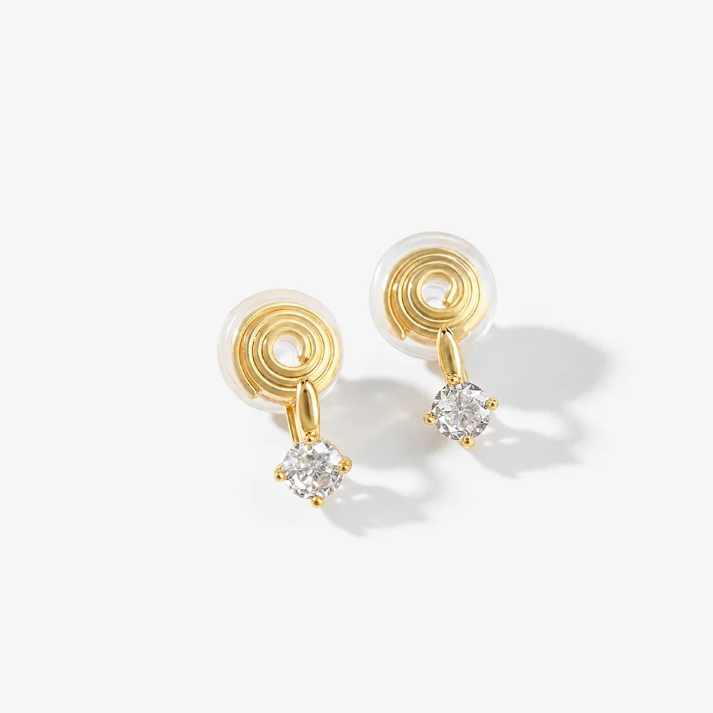 Front view of gold solitaire drop clip-on studs on a light gray background