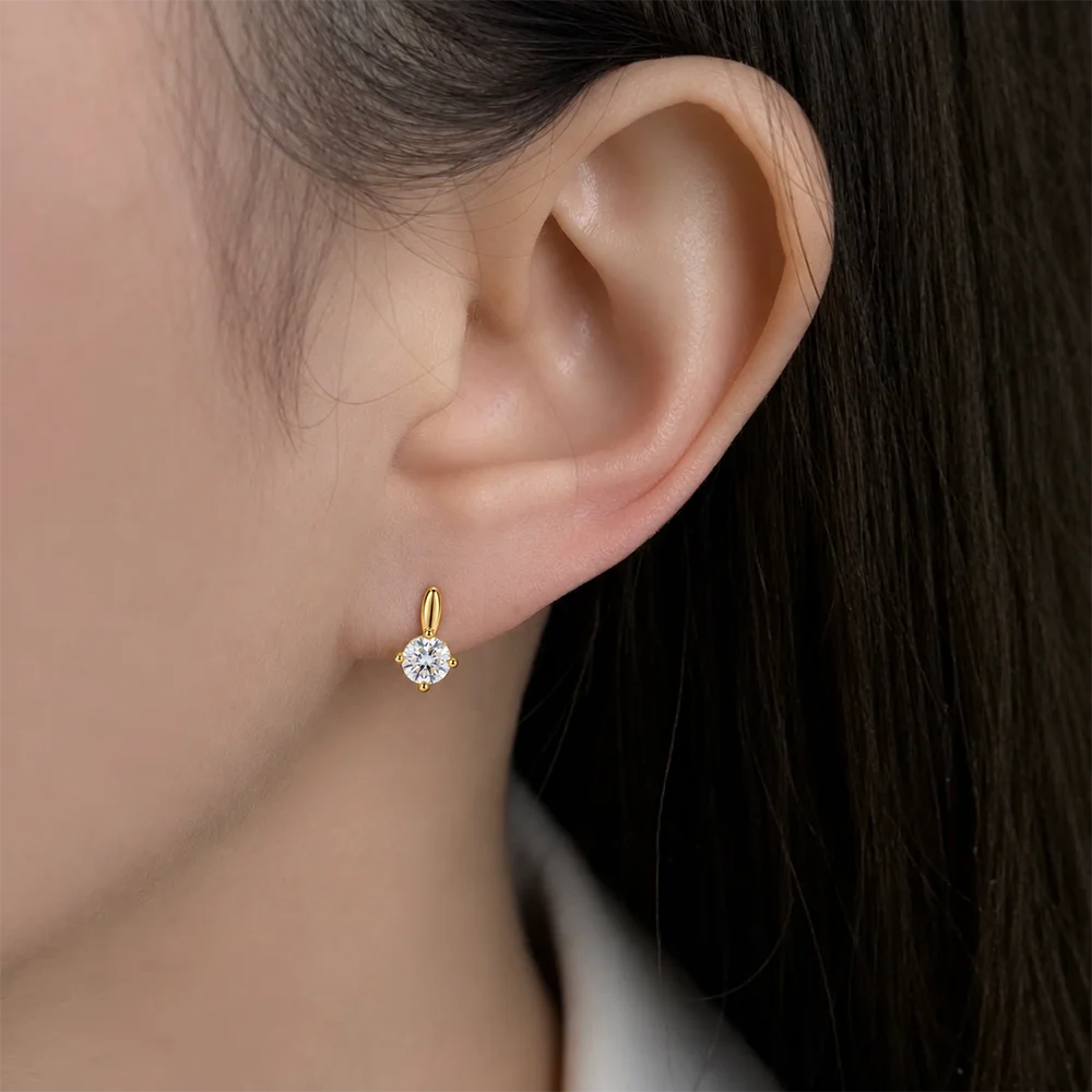 Tiny gold solitaire CZ clip-on stud worn on a non-pierced earlobe