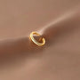 Manchette d'oreille en or pavé étincelant, présentée sur un morceau de tissu satiné, mettant en valeur son fini lustré et ses pierres brillantes.