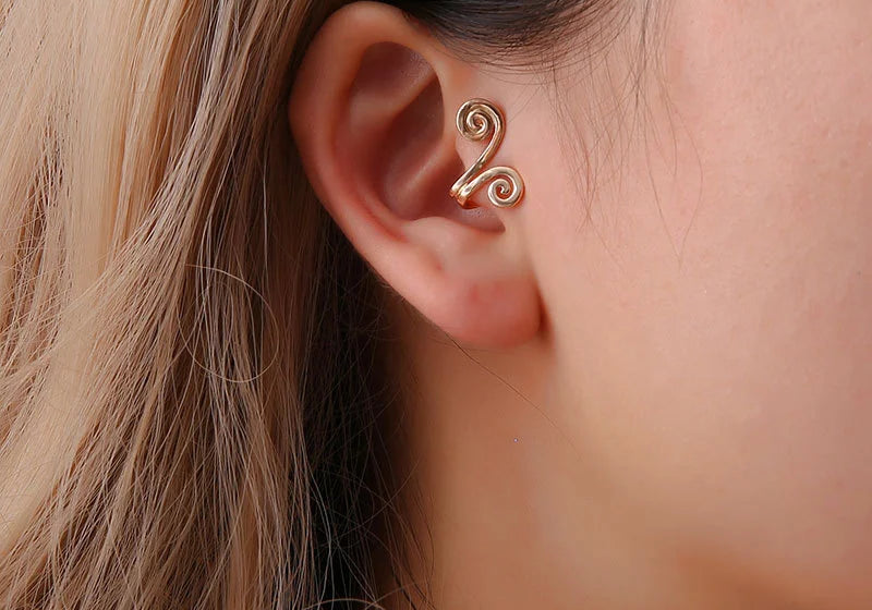 Spiral Helix Tragus Cuff in Gold worn on a model's ear, close-up side view