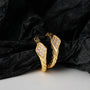 Gold Sterling silver Ouroboros Ear Cuff pair displayed on black fabric against white background, front view