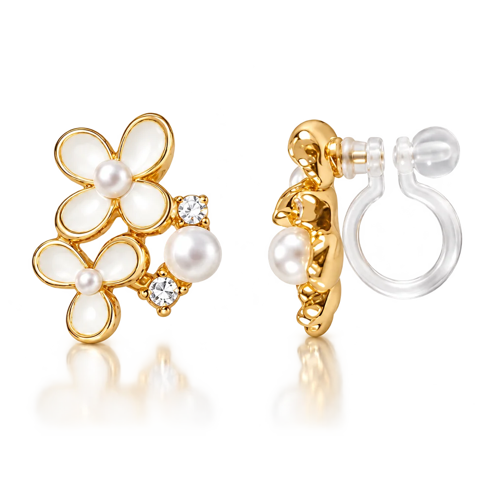 A pair of gold hoop earrings with white pearl flower motifs and small clear crystal accents, shown on a clean white background with one earring facing forward and the other angled to show the post and clear elastic clip on back.