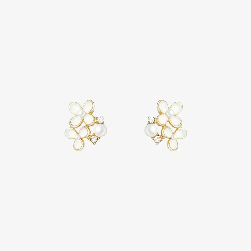 A pair of White Blossom Pearl invisible clip-on earrings, showcasing delicate white flowers, faux pearls, and cubic zirconia, isolated on a white background.