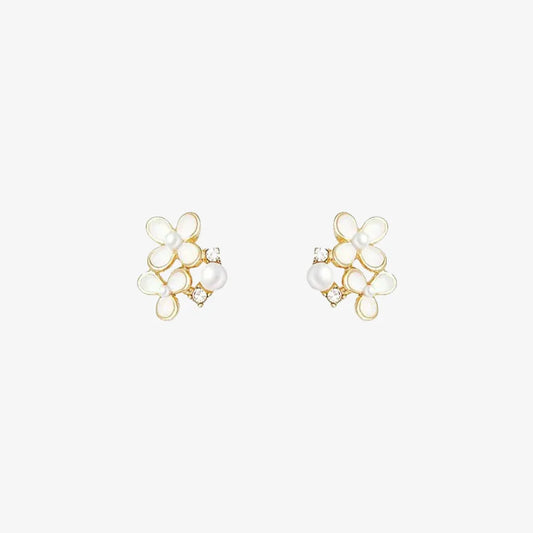 A pair of White Blossom Pearl invisible clip-on earrings, showcasing delicate white flowers, faux pearls, and cubic zirconia, isolated on a white background.