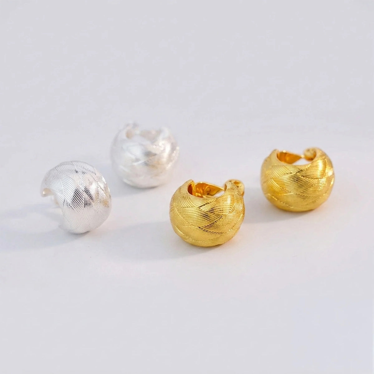 Woven dome hoop clip-on earrings in gold and silver-tone finishes side by side