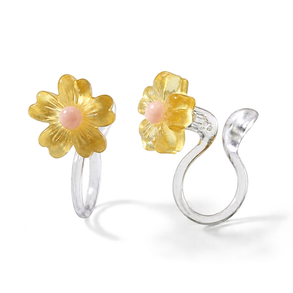 Close-up of the translucent yellow resin daisy petals and the clear stud invisible clip-on mechanism for non-pierced ears.