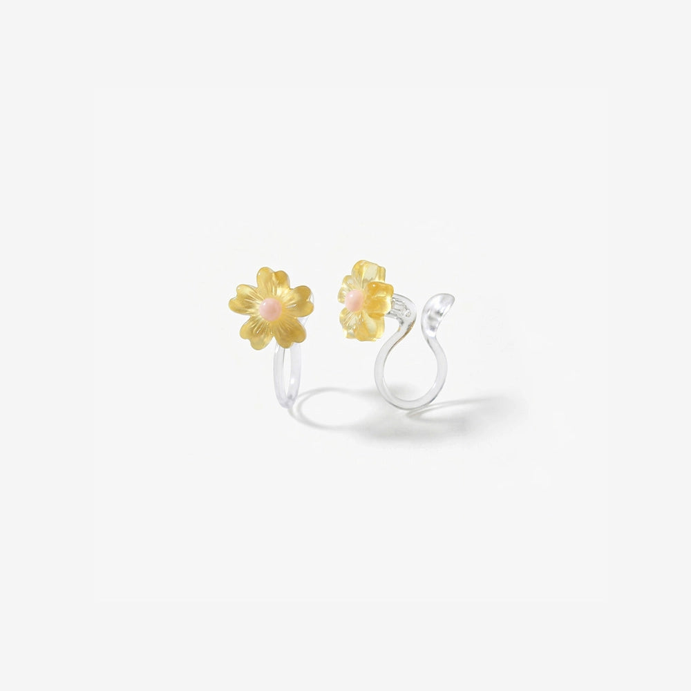 Close-up of the translucent yellow resin daisy petals and the clear stud invisible clip-on mechanism for non-pierced ears.